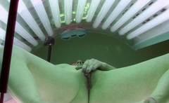 Brunette plays with her pussy in solarium